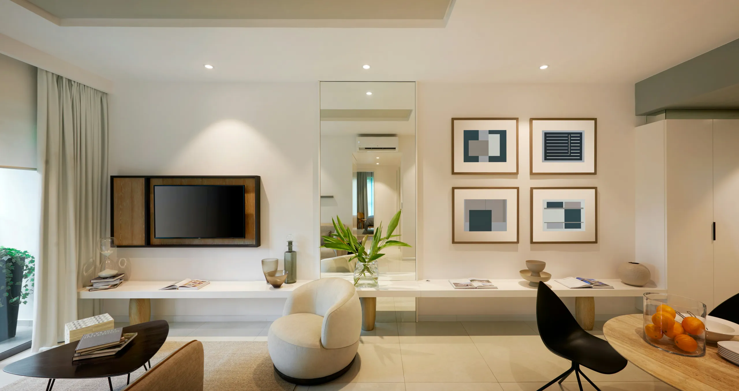 Elegantes Wohnzimmer mit TV-Board, Wandbildern und rundem Sessel