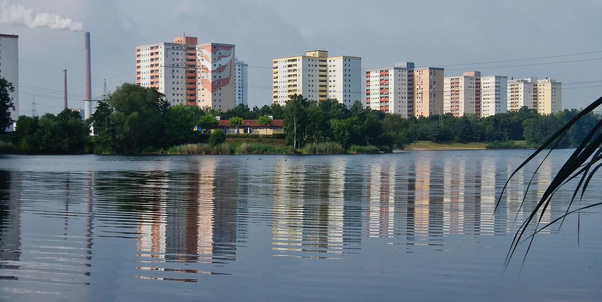 Hochhäuser der Mainparkstraße spiegeln sich im Mainparksee in Mainaschaff