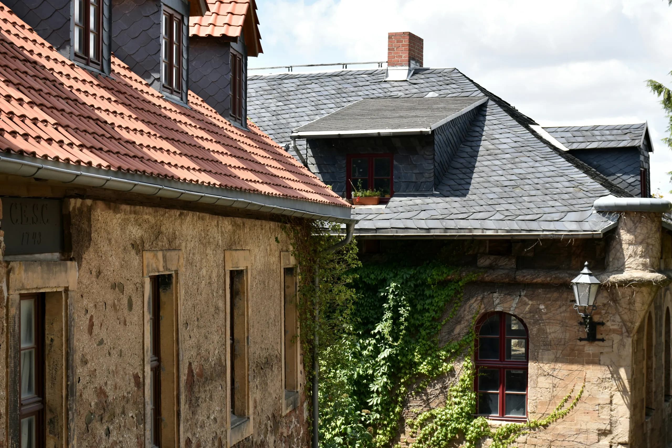 Historische Dächer mit roten Ziegeln und Schieferschindeln