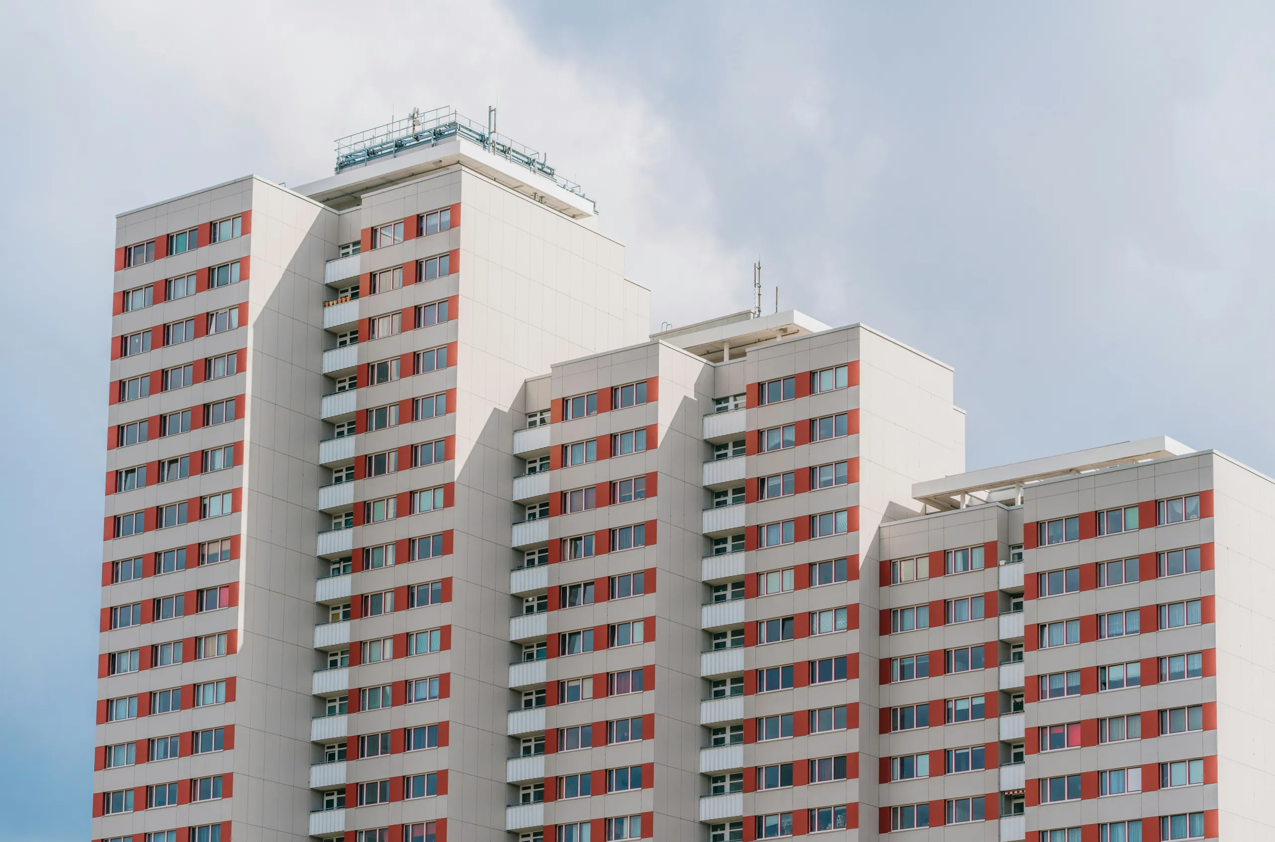 Weiße Wohnhochhäuser mit rot abgesetzten Fensterachsen