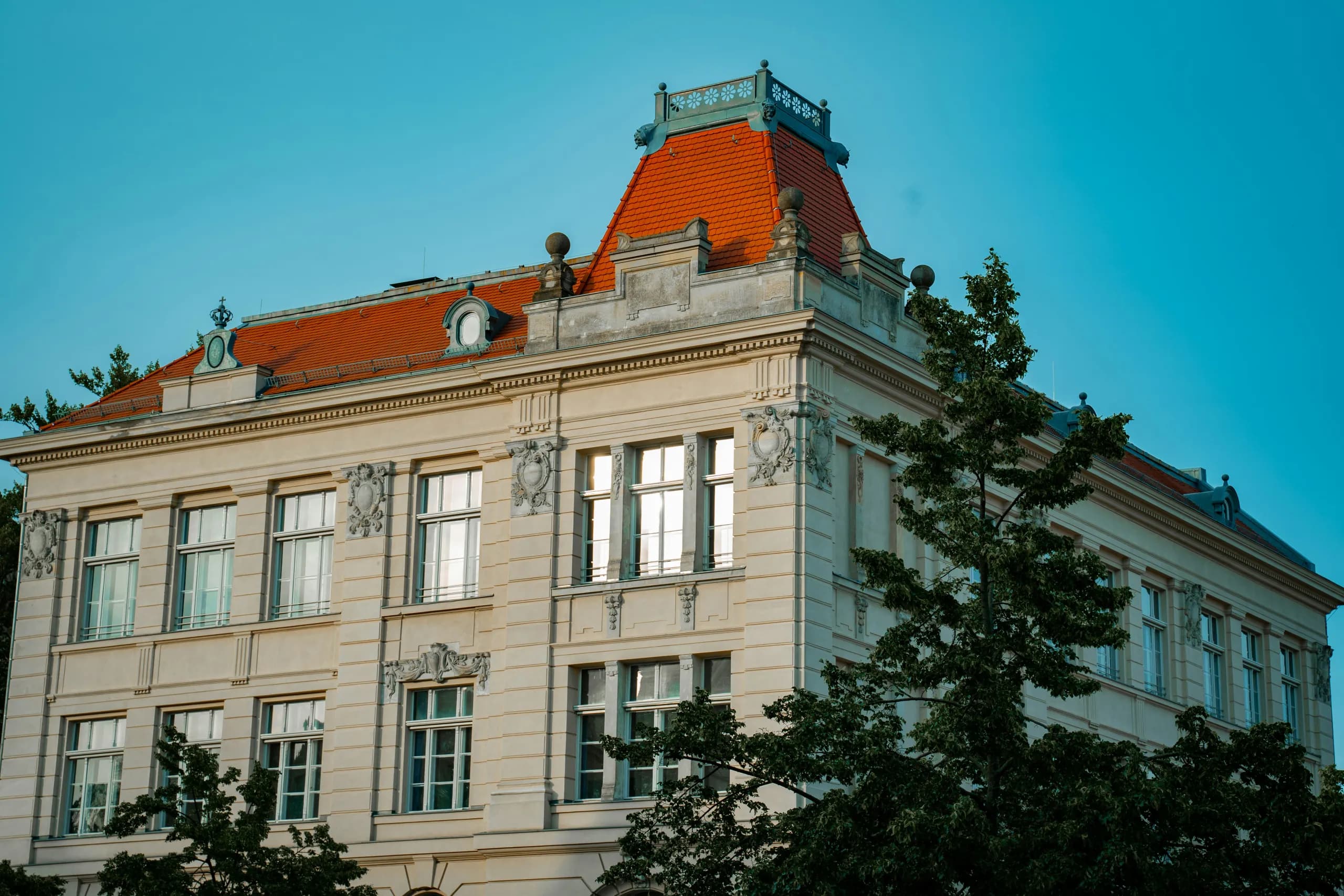 Gründerzeit-Eckhaus mit Stuckfassade und orangefarbenem Dach